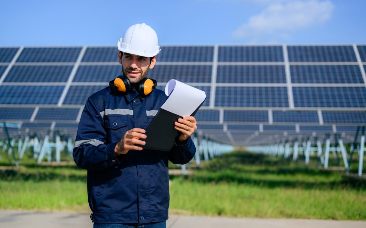 engineer-worker-portrait-with-solar-panel-at-solar-farm.jpg